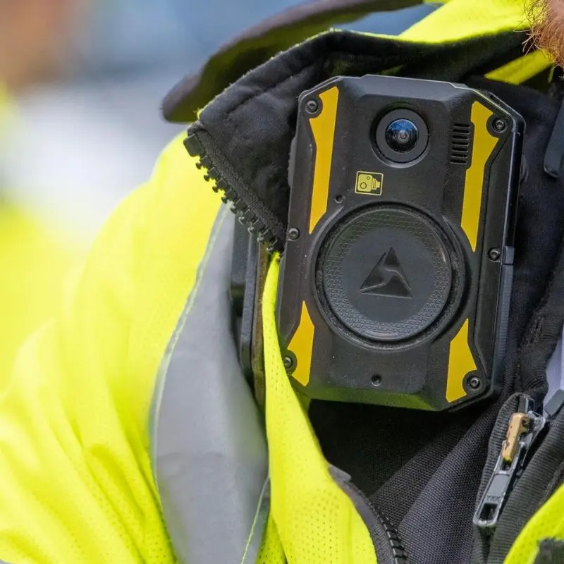 Nærbillede af en bodycam der bæres på en gul refleksvest under en trafikopgave